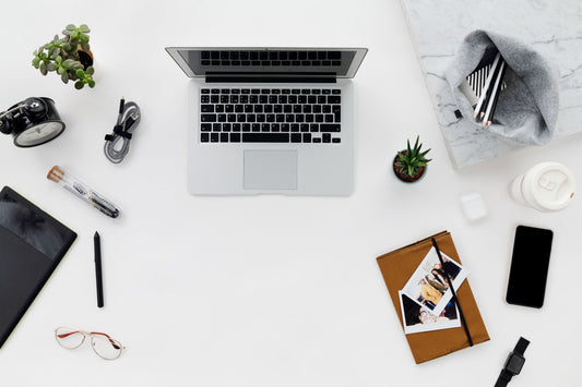 Overhead view of a minimalist desk setup with a laptop and a neatly coiled cable