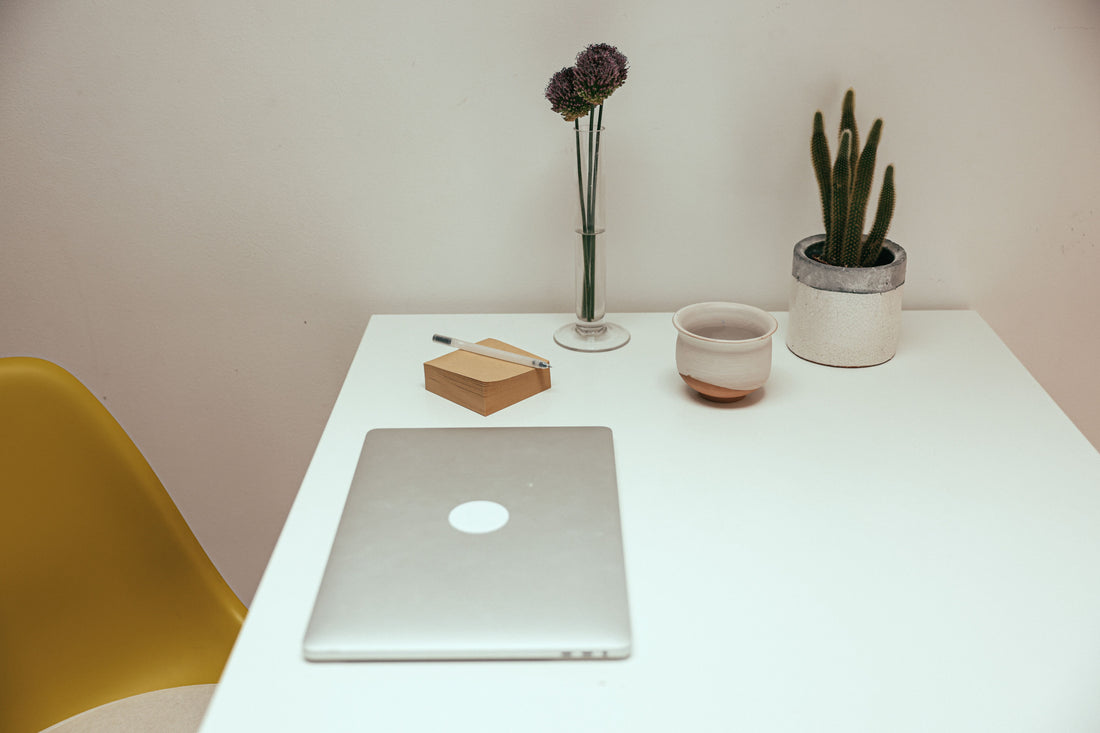 A clean, minimal home office desk with just a few neatly organized essentials