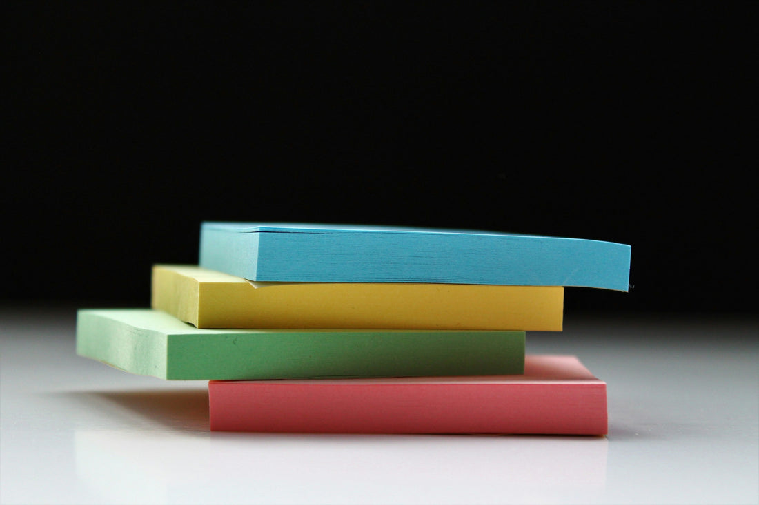 Stack of colorful sticky notes in blue, yellow, green, and red